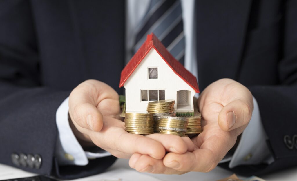 Pessoa segurando uma casa e dinheiro, simbolizando sua consquista com consórcio.